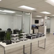 Modern office with conference room, desks, and abstract sculpture.