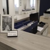 Office reception desk with a vase, picture frame, and business card.